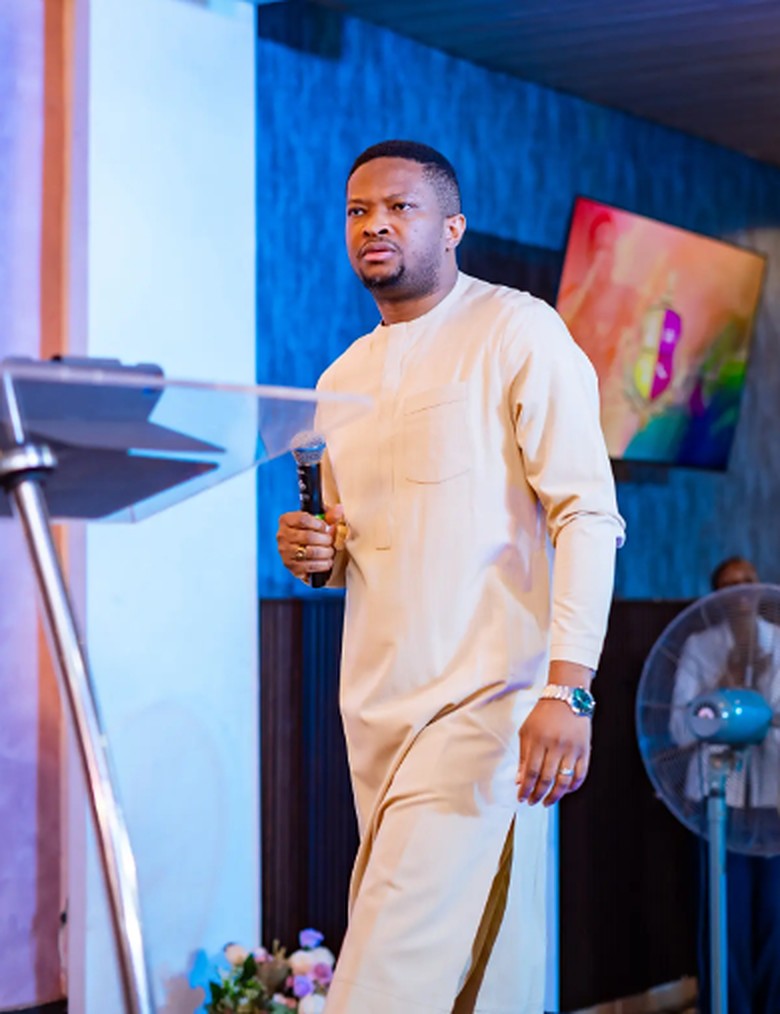 Pastor Godswill Oyor walking across the stage with a microphone